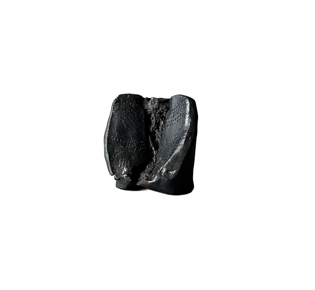 Black stoneware sculpture, Chronolith 02, short irregular form, torn open, with incised geometric marks.
